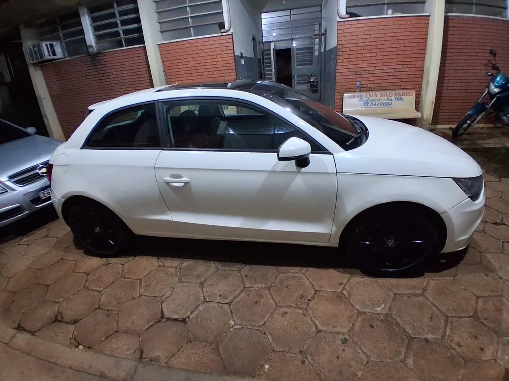 Carro branco parado em pátio de delegacia