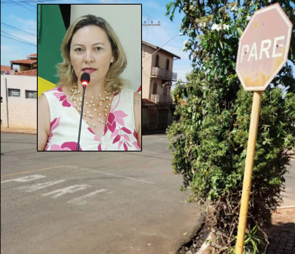 Cruzamento de ruas, com uma placa de parada obrigatória à direita, além dos dizeres PARE no lado esquerdo da imagem, no destaque uma muilher loira de blusa florida