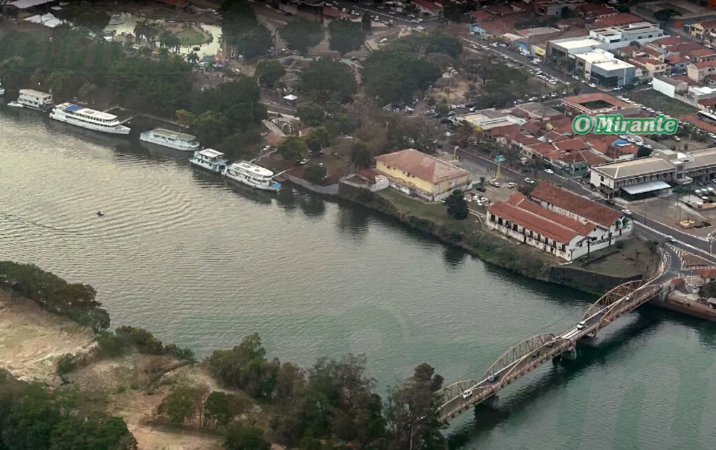 imagem aérea da orla de uma cidade, com rio à frente e imóveis ao fundo