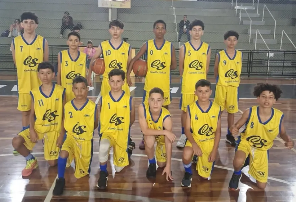 equipe masculina de basquete vestindo uniforme amarelo em quadra de chão marrom