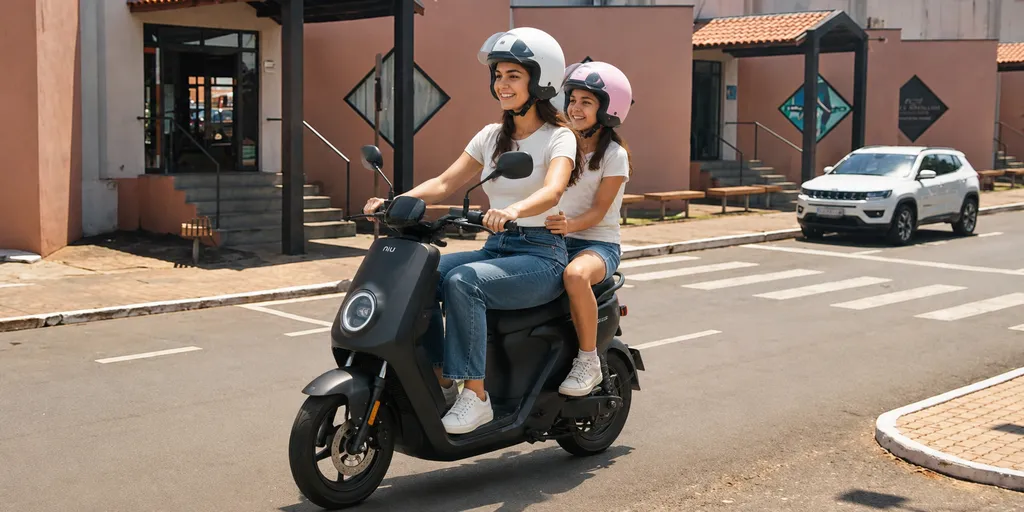 duas jovens andam num scooter preto em frente ao barra bonita shopping